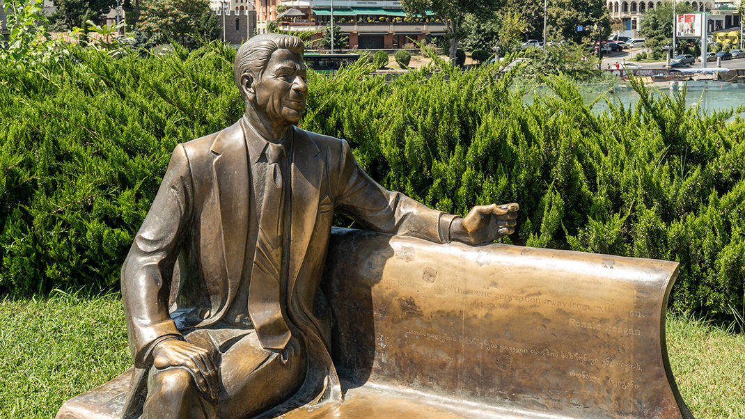 A sculpture depicting Ronald Reagan on a bench
