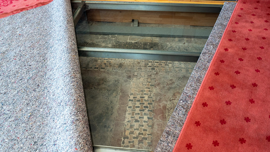 The antique floor covering is visible below