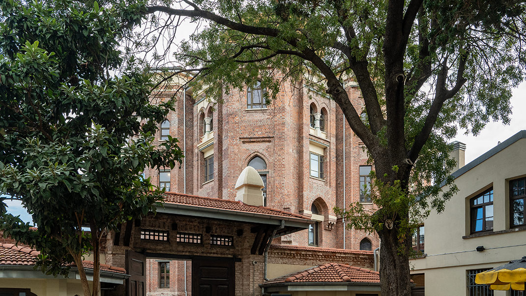 Здание виднеется за деревьями